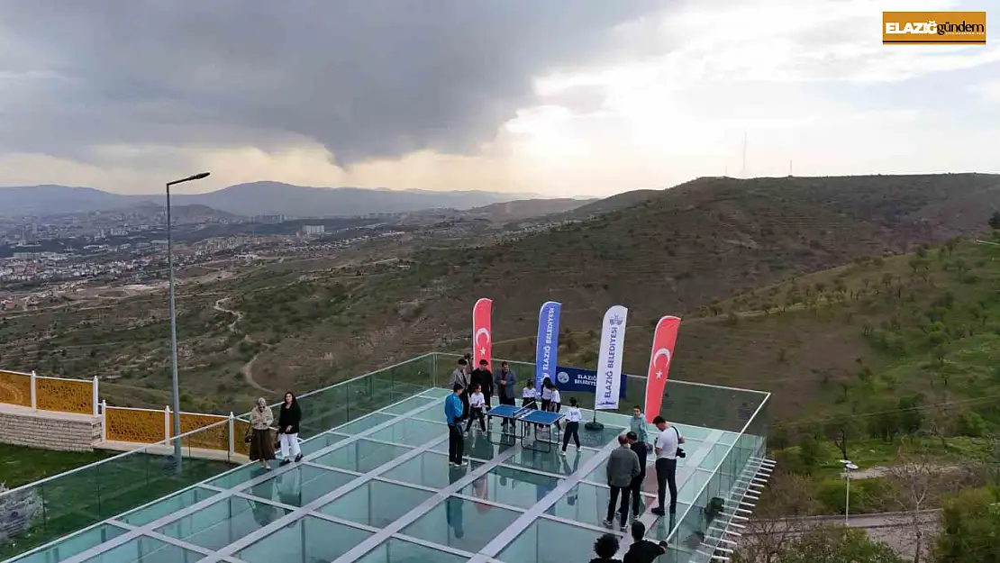 Cam teras üzerinde masa tenisi karşılaşması, renkli görüntüler oluşturdu
